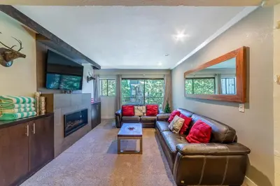 a living room with a leather couch and a tv at Quaint 1B/1BA Canyon Lodge Condo: Jacuzzi & More! in Mammoth Lakes