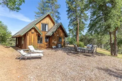 a log cabin with two chairs and a bench at Casa Manzanita in Midpines! 26 miles to Yosemite! in Midpines