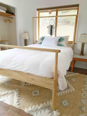 a large bed with a wooden frame in a bedroom at Casa Manzanita in Midpines! 26 miles to Yosemite! in Midpines