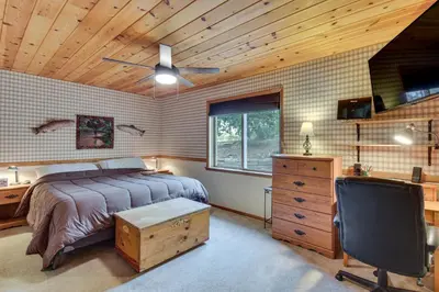a bedroom with a bed and a desk with a chair at Deck and Wooded Views 5-Acre Auberry Retreat! in Auberry