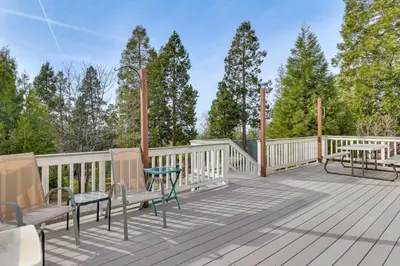 a wooden deck with benches and a table at Deck and Wooded Views 5-Acre Auberry Retreat! in Auberry