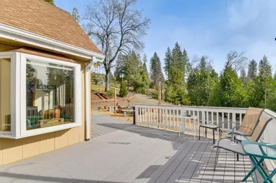 a porch with two chairs on a house at Deck and Wooded Views 5-Acre Auberry Retreat! in Auberry