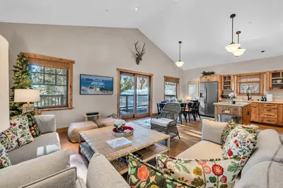 a living room with couches and a table and a kitchen at Cozy Tahoe Getaway - Walk to Lake & Quiet Deck in Carnelian Bay