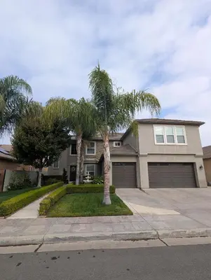 a house with palm trees in front of it at Spacious 5-bedroom 3-bath house in NW Fresno in Fresno