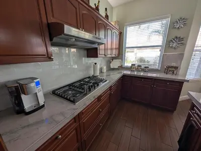 a kitchen with wooden cabinets and a stove top oven at Spacious 5-bedroom 3-bath house in NW Fresno in Fresno