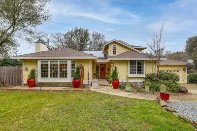 a yellow house with a yard at Hot Tub and Huge Patio Home 5 Mi to Old Town Auburn in Auburn