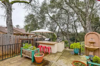 a patio with a table and chairs and an umbrella at Hot Tub and Huge Patio Home 5 Mi to Old Town Auburn in Auburn