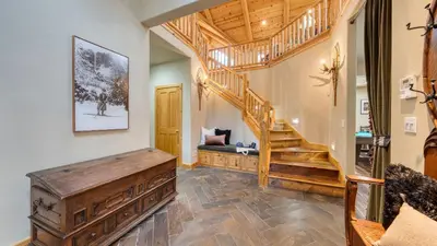 a living room with a wooden staircase in a house at Truckee Mountain Cabin with Hot Tub Game Room Forest Views Gray Wolf Lodge by AvantStay in Truckee