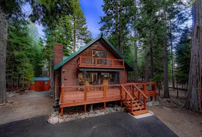 a cabin in the woods with a large deck at Whispering Pines Cabin For 6 in Carnelian Bay