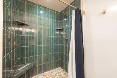 a bathroom with a shower with green tile at Whispering Pines Cabin For 6 in Carnelian Bay