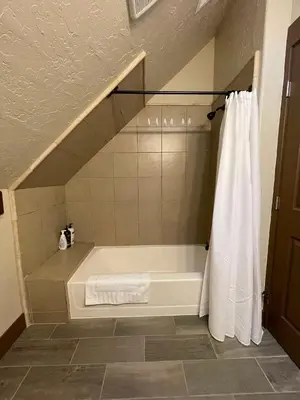 a bathroom with a bath tub with a shower curtain at The Little Dipper Cabin in Shaver Lake