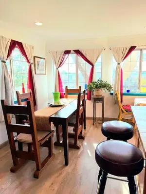 a dining room with a table and chairs and windows at Hot Tub, Farm Chic Shingle Springs Birders Heaven in Shingle Springs