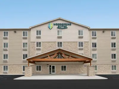 a large building with a sign on top of it at WoodSpring Suites Manteca - Stockton South in Manteca