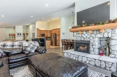 a living room with couches and a stone fireplace at Snowcreek 704 in Mammoth Lakes
