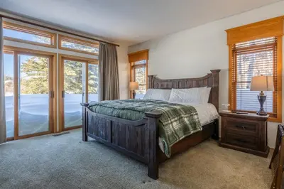 a bedroom with a large bed and windows at Snowcreek 704 in Mammoth Lakes