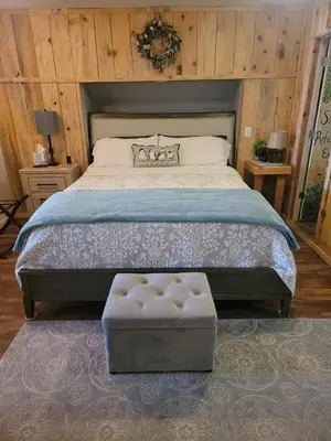 a bedroom with a large bed with a ottoman in it at Red Barn Haven-Your romantic getaway to Yosemite in Oakhurst