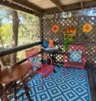 a porch with two chairs and a table and a table at Red Barn Haven-Your romantic getaway to Yosemite in Oakhurst