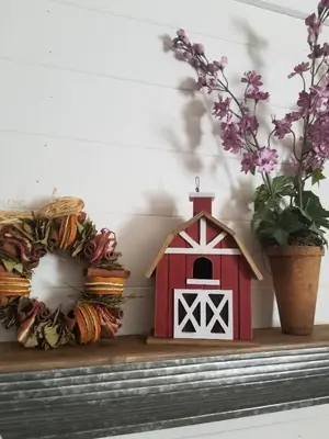 a small red barn sitting on a shelf with flowers at Red Barn Haven-Your romantic getaway to Yosemite in Oakhurst