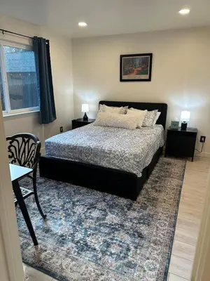 a bedroom with a bed and a table and a chair at Hidden Gem House incredible location remodeled in South Lake Tahoe