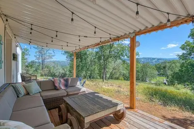 a screened in porch with a couch and a table at Yosemite Boho Bungalow, Pet Friendly & Mtn Views! in Coarsegold