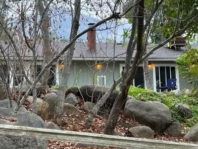 a house with a yard with rocks in front of it at River Retreat near Sequoia National Park in Three Rivers