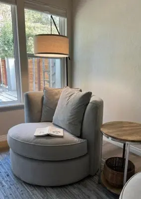 a living room with a chair with a book on it at River Retreat near Sequoia National Park in Three Rivers