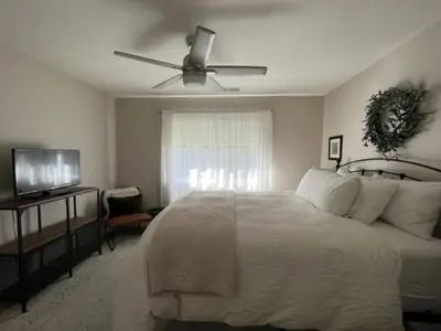 a bedroom with a white bed and a ceiling fan at River Retreat near Sequoia National Park in Three Rivers