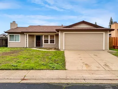 a house with a garage and a driveway at Spacious 4BR Family Home Free Parking, Fast WiFi, Near Galleria & Fountains in Roseville