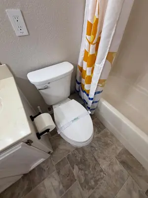 a bathroom with a toilet and a shower curtain at Spacious 4BR Family Home Free Parking, Fast WiFi, Near Galleria & Fountains in Roseville