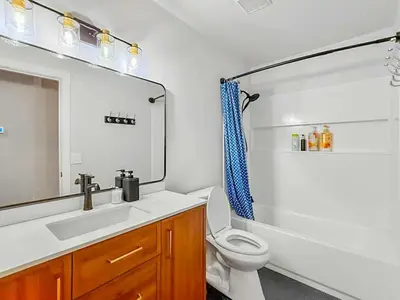 a bathroom with a sink and a toilet and a mirror at Spacious 4BR Family Home Free Parking, Fast WiFi, Near Galleria & Fountains in Roseville