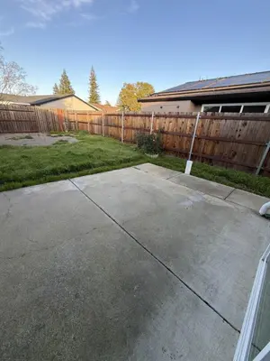 a driveway in a yard next to a wooden fence at Spacious 4BR Family Home Free Parking, Fast WiFi, Near Galleria & Fountains in Roseville