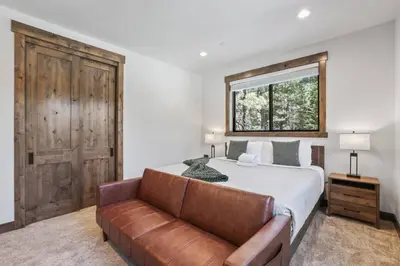 a bedroom with a bed and a leather couch at Paradise on Pioneer - New 6 Bedroom w Pool Table in South Lake Tahoe
