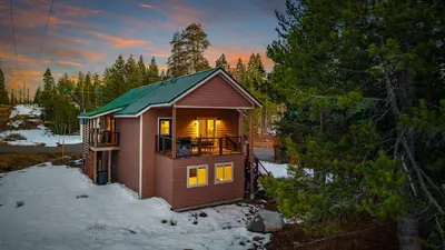 a small cabin with a green roof in the snow at Mountain Retreat - Sleeps 7 - Canoe - Fireplace in Soda Springs