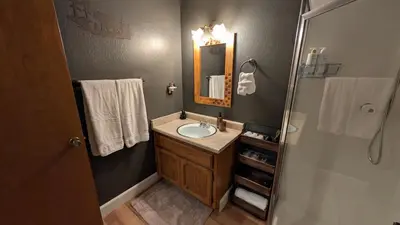 a bathroom with a sink and a mirror and a shower at Sierra Cabin w NEW Hot Tub Walk to Town in Twain Harte