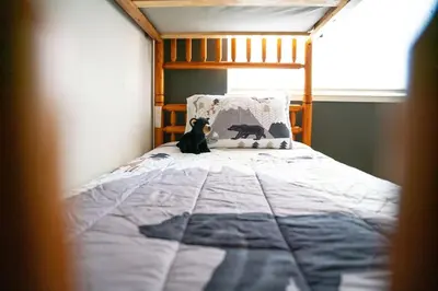 a dog sitting on a bed in a bedroom at Sierra Cabin w NEW Hot Tub Walk to Town in Twain Harte