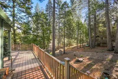 a wooden deck with a porch in the woods at Modern Cabin Escape wGame Room, Huge Deck, WIFI in Arnold