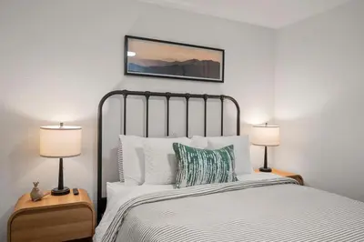 a bedroom with a bed with two lamps on tables at Modern Cabin Escape wGame Room, Huge Deck, WIFI in Arnold