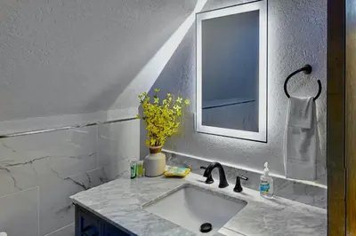 a bathroom sink with a mirror and a vase of flowers at Yosemite Escape in White Wolf