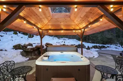 a jacuzzi tub under a wooden roof with lights at Yosemite Spirit in White Wolf