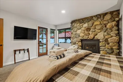 a large bedroom with a stone wall with a fireplace at Yosemite Spirit in White Wolf