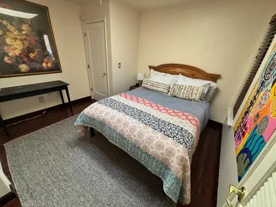 a bedroom with a bed and a table in it at Cozy Lake View 4Bd 2,5Br Retreat in 5 Acres, Hot Tub and more in Auburn