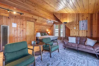 a bedroom with a bed and a couch and a table at Midiron Golf Cabin cabin in Tahoe Vista