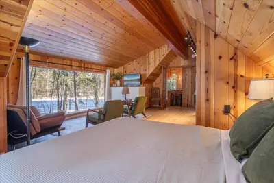 a bedroom of a cabin with a bed and a living room at Midiron Golf Cabin cabin in Tahoe Vista