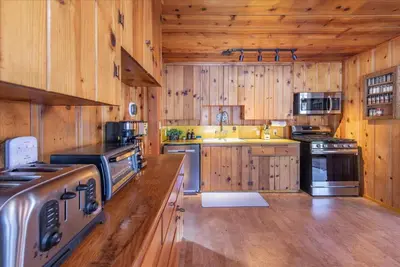 a large kitchen with wooden walls and wooden floors at Midiron Golf Cabin cabin in Tahoe Vista