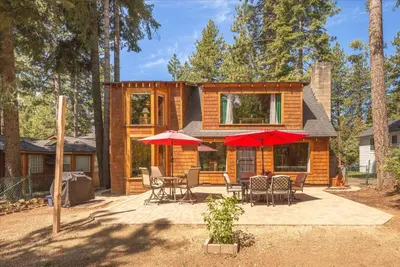 a house with a patio and red umbrellas at Midiron Golf Cabin cabin in Tahoe Vista