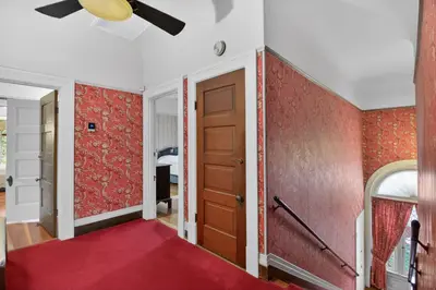 a hallway with red walls and a red carpet at The Spalding House Comfort in Visalia home in Visalia