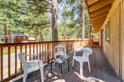 three chairs and a table on a deck with trees at Walk to Lake Tahoe Family Retreat with Deck! in Incline Village