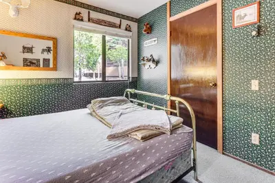 a bedroom with a bed in a room with green walls at Community Perks and Watercrafts Shaver Lake Condo in Shaver Lake