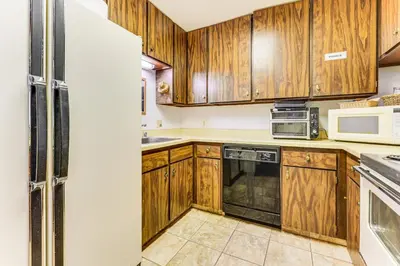 a kitchen with wooden cabinets and a refrigerator at Community Perks and Watercrafts Shaver Lake Condo in Shaver Lake