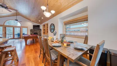 a kitchen and dining room with a wooden table and chairs at 2 Truckee Cabin • Sleeps 20 • Hot tub • Games • Near Donner Lake Donner Ridge Alplenglow Chalet by AvantStay in Truckee